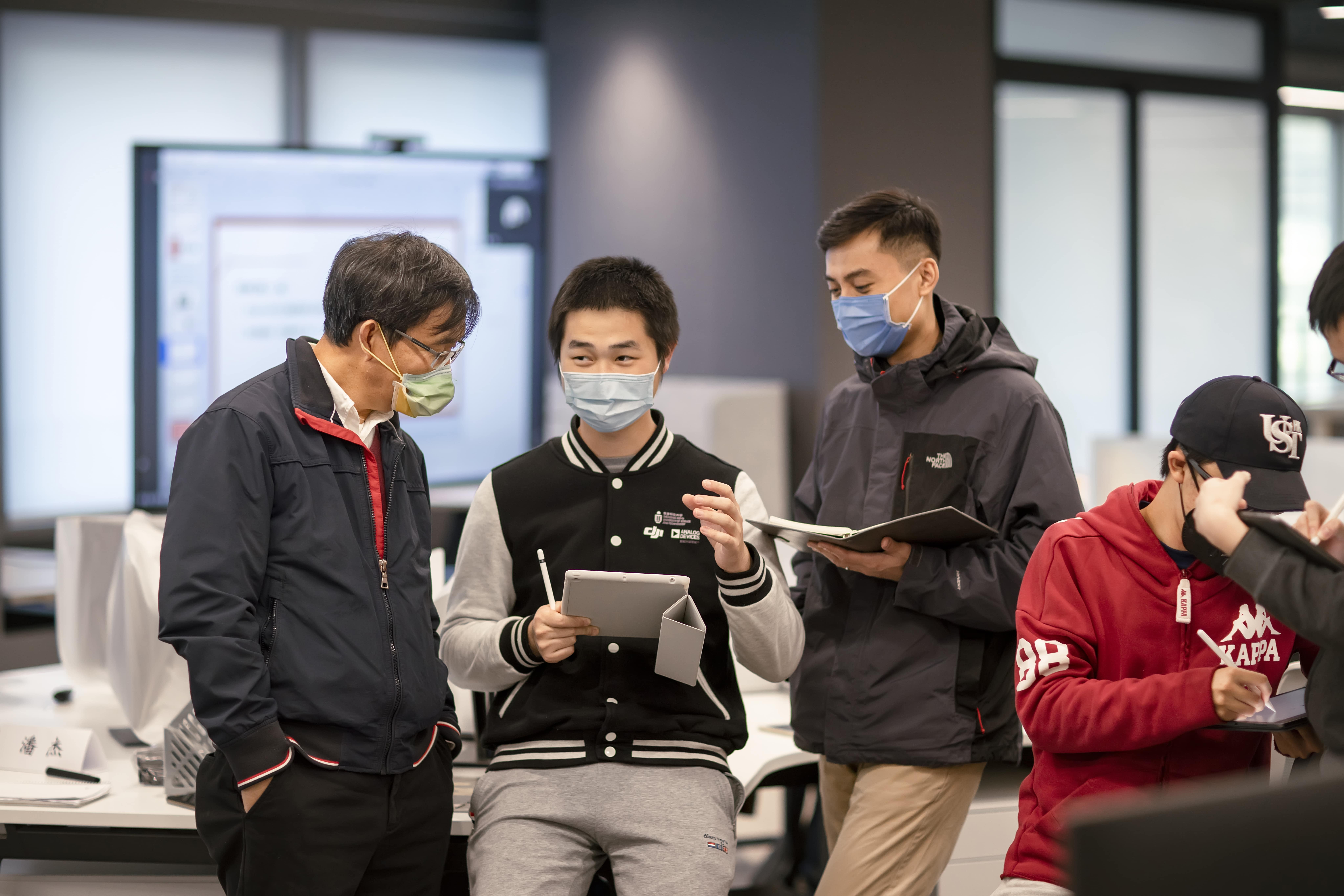 Research students are exchanging ideas with Prof. Zexiang Li.